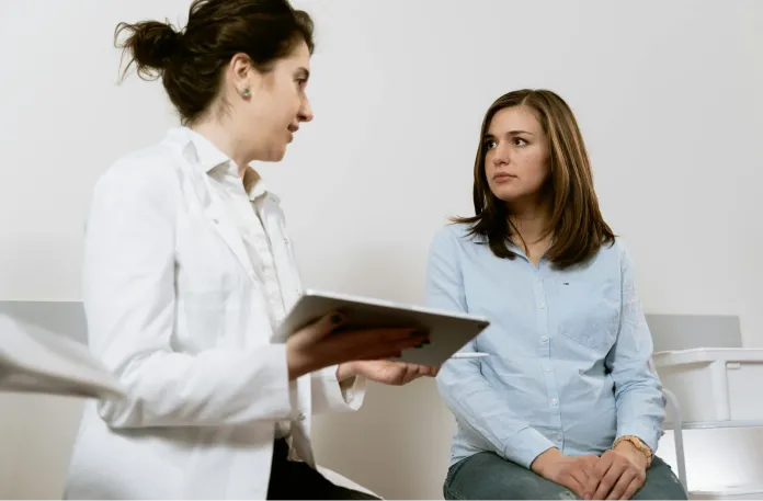 In a medical consultation, a woman speaks with a doctor